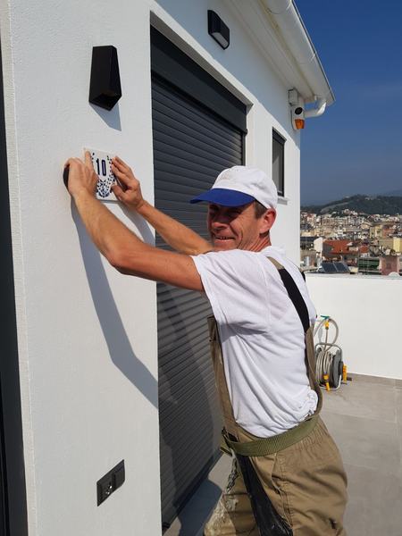 Τεχνικός τοποθετεί εξάρτημα σε εξωτερικό τοίχο